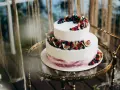 Elegancki tort piętrowy na 40 osób, ozdobiony świeżymi figami, borówkami i malinami. Idealny na wyjątkowe przyjęcie.