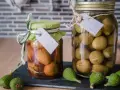 Zwei Gläser mit eingelegten unreifen Feigen, eines in Essig, das andere in Salzlake. Perfekt für unreife Feigen Rezepte.