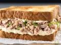 Pyszna kanapka z tuńczykiem, pełna kremowego majonezu i świeżej sałaty, idealna na szybki lunch.