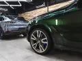 Lśniące, zielone BMW i szare Porsche w garażu. To efekt profesjonalnego auto detailingu, który przywraca blask lakierowi i dba o każdy detal pojazdu.