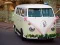 Klasyczny VW Transporter, ozdobiony różową wstążką i kwiatami, gotowy do transportu gości. Zasady dopisywania informacji o noclegu i transporcie dla gości są jasne.
