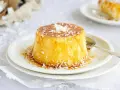 Delicioso flan de coco, cubierto con caramelo dorado y coco rallado, listo para disfrutar.