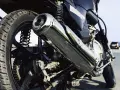 Detalle de la rueda trasera y el escape cromado de una motocicleta. Si te preguntas cuanto cuesta homologar un escape, este podría ser el tuyo.