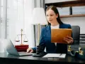 Prawniczka pracuje nad sprawą wdrożenie windykacji, analizując dokumenty na laptopie.