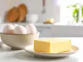 Schüssel mit Eiern und Butter auf einem Teller. Die Frage bei welcher Temperatur stockt Ei wird hier nicht beantwortet.