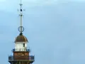 Szczyt latarni morskiej w Gdańsku z wiatrowskazem i kulistą ozdobą.