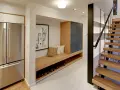 Ideas para decorar un pasillo interior: un banco de madera con almacenamiento, cuadros y una escalera moderna.