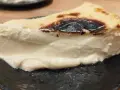 Rebanada cremosa de pastel vasco, con su característico exterior tostado y un interior suave y delicioso.