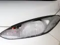 Kleine Wassertropfen bedecken das Glas des weißen Autoscheinwerfers. Feuchtigkeit im Scheinwerfer ist sichtbar.