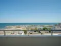 Vista dal balcone dell'hotel Acropolis Cattolica: spiaggia, porto turistico e mare azzurro sotto un cielo limpido.