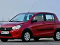 Czerwony Suzuki Celerio z polskimi tablicami rejestracyjnymi WB 2175L zaparkowany na zewnątrz.