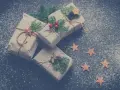 Julklappar inslagna i brunt papper med granris och stjärnor. Perfekta julkort idéer för en mysig julkänsla.