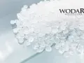 Granulat polipropylenowy WODARO PROFESSIONAL. Czyste, białe granulki tworzą tło dla logo.