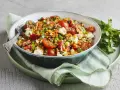 Ein bunter rote Linsen Salat mit Tomaten, Mozzarella und Nüssen, appetitlich angerichtet.
