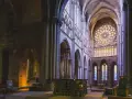 Wnętrze katedry z witrażami i ołtarzem. Miejsce sprzyjające refleksji nad teologią i duchowością.