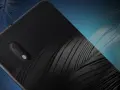 Tył telefonu Alcatel 1B z teksturą przypominającą pióra, na tle stylizowanych piór.