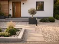 Moderner Vorgarten gestalten: Kieswege, klare Linien und eine kleine Olive vor dem Haus.