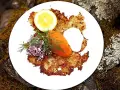 En tallrik med krispiga rårakor, serverade med rom, gräddfil, dill, rödlök och citron. Ett härligt råraka recept!
