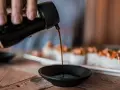 Sojasauce wird in eine Schale gegossen, während Sushi im Hintergrund wartet. Auch in der Schwangerschaft kann man vorsichtig genießen.