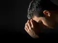 A man bows his head in prayer, hands clasped, reflecting the repentance meaning in the bible.