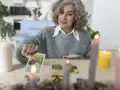 Kobieta z siwymi włosami układa karty tarot, szukając wskazówek dotyczących umiarkowanie uczuć.