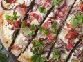 Flammkuchen mit Speck, roten Zwiebeln und frischen Kräutern – tolle Flammkuchen Belag Ideen für jeden Geschmack.
