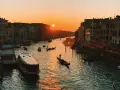 Tramonto sul Canal Grande, con gondole e vaporetti. Un'immagine da uno dei tanti punti panoramici di Venezia, con il sole che illumina l'acqua.