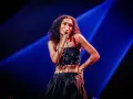 La chanteuse soul française, avec sa voix envoûtante, captive le public sous les projecteurs bleus.