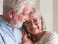 Uśmiechnięta para seniorów, która cieszy się życiem i przywilejami po 75 roku życia. Ich miłość kwitnie.