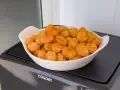 Ñoquis dorados y crujientes en una fuente blanca, recién salidos de la freidora de aire Cosori. ¡Perfectos para picar!