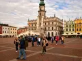 Rynek w Zamościu, idealne miejsce na wycieczki objazdowe z Lublina. Kolorowe kamienice i ratusz tworzą malowniczą scenerię dla spacerujących turystów.