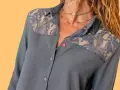 Chemise grise avec empiècements en dentelle sur les épaules. Le boutonnière fille est sur le côté gauche.