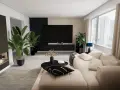 Modernes Wohnzimmer gestalten: Ein beiger Sofa, schwarzer Couchtisch, Kamin und Pflanzen schaffen Gemütlichkeit.