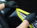 Rękawiczki ochronne zabezpieczają lakier podczas prac nad tym, jak usunąć rysy z auta.
