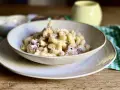 Piatto di pasta con prosciutto crudo, formaggio grattugiato e una salsa cremosa. Un classico confortante.