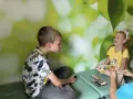 Chłopiec i dziewczynka, która ma 3 latek, bawią się grą sensoryczną.