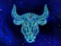 Błękitny, neonowy byk z gwiazdami na tle. Symbol zodiaku Byk, jaki żywioł? Ziemia, siła i stabilność.
