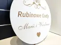 Okrągła tablica z napisem "Rubinowe Gody Marii i Wiesława" i cyfrą "40" upamiętnia 40 rocznicę ślubu.
