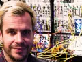 Marcin Staniszewski muzyk, w otoczeniu skomplikowanej aparatury syntezatorowej, tworzy dźwiękowe pejzaże.