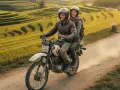 Para podróżuje motocyklem przez tarasowe pola ryżowe w Wietnamie. Warto zabrać do Wietnamu wygodne ubrania i kask.