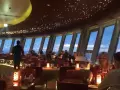 Gemütliches Alexanderplatz Restaurant mit Sternenhimmel-Decke und Panoramablick auf die Stadt bei Nacht.