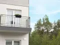 Nowy balkon z kwiatami, z którego roztacza się widok na las. Czy to miejsce wolne od podatku od balkonu?