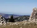Deux cairns de cailloux marquent le paysage montagneux, offrant des repères visuels sur le sentier.