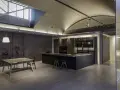 Moderna cocina office con isla central, muebles oscuros, estanterías y mesa de comedor.