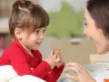 Ein kleines Mädchen und eine Frau sprechen liebevoll miteinander. Ein Moment der psychosexuellen Entwicklung, der Geborgenheit und Vertrauen schafft.