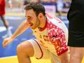 Arkadiusz Moryto w białej koszulce z czerwonymi wzorami, w akcji na boisku.