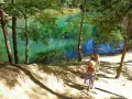 Dwie dziewczynki w słomkowych kapeluszach idą ścieżką nad turkusowe jezioro. Idealne miejsce, gdzie z dzieckiem na weekend.