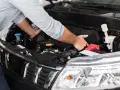 Meccanico controlla il motore per problemi al motorino d'avviamento.