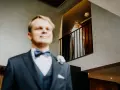Pan młody w garniturze i panienka młoda w bieli na balkonie. Zastanawiasz się, ile bierze fotograf za wesele?