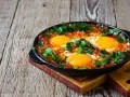 Jajka sadzone w sosie pomidorowym z natką pietruszki, idealne na śniadanie keto. Proste dieta keto przepisy.